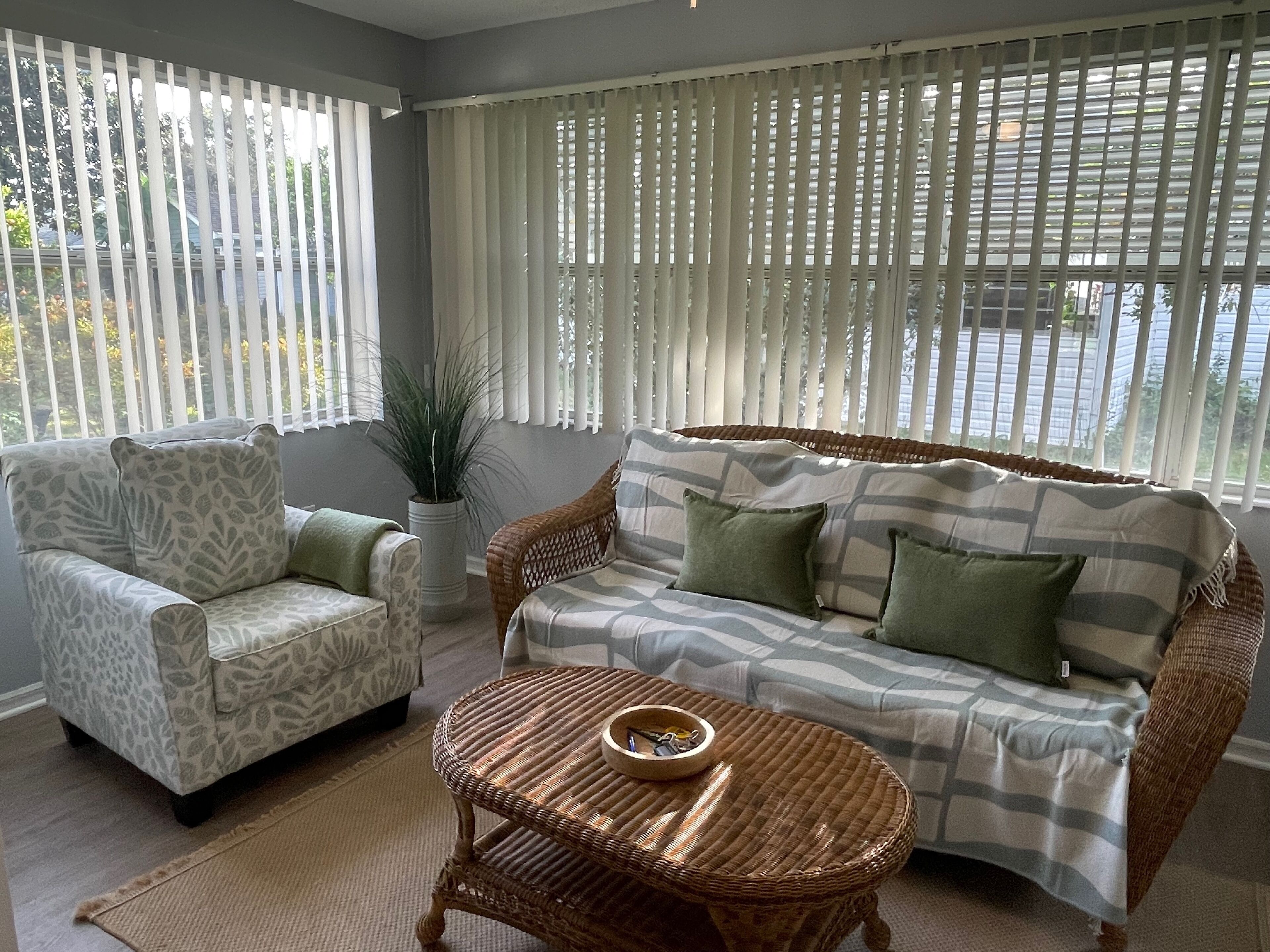 A living room with a sofa, armchair, and a small round table.