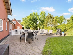 A patio area with a brick floor, outdoor furniture, and a barbecue grill. - 5 Star Holiday Home in Hjorring (Hjørring)