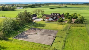 A large, open field with a farmhouse and a paved area in the foreground. - 5 Star Holiday Home in Hjorring (Hjørring)