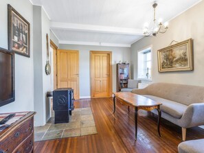 Un salon comprenant un canapé, une table basse, une cheminée, des portes en bois et une bibliothèque.