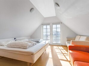 Une chambre à coucher avec un lit, une chaise et une fenêtre équipée de stores.