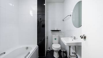 A modern bathroom with a bathtub, toilet, and sink.