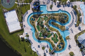 An aerial view of a resort with a winding pool, multiple lounge areas, and a separate building with a pool. - Lakefront Luxury Retreat Private Pool & Movie Theater 367 (Kissimmee)