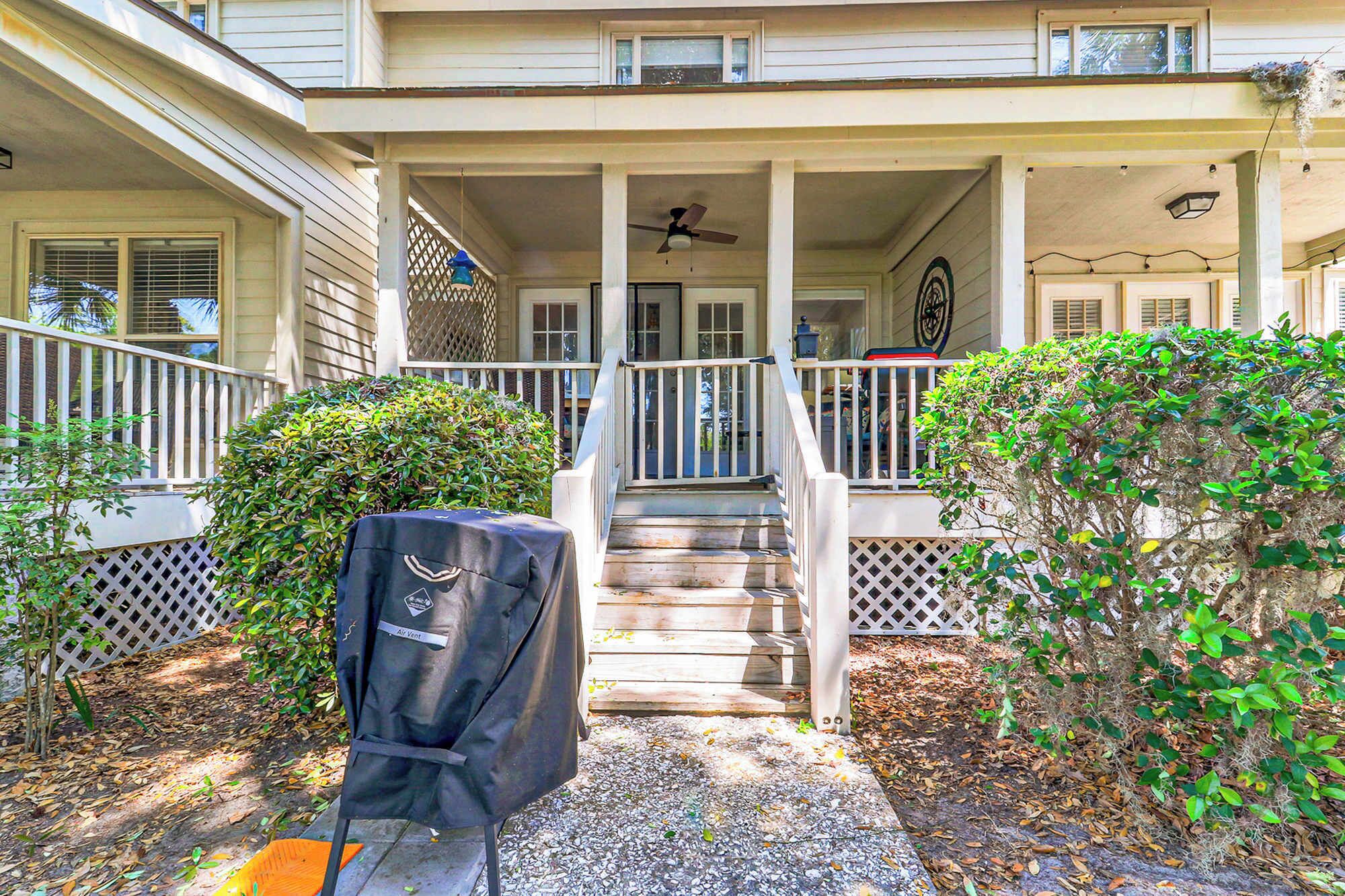 A two-story house with a covered porch, a staircase, and a fan.