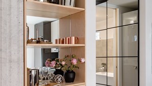 A modern kitchen with wooden cabinetry, copper mugs, and decorative items.