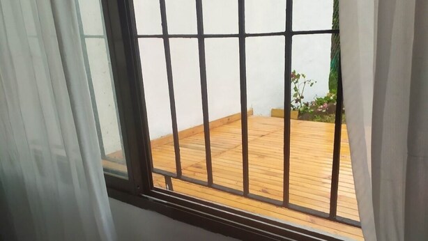 A room with a window overlooking a wooden deck. - CASA CHALET LAMAR (whole house) (Santa Clara del Mar)