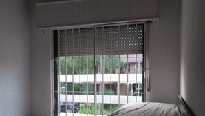 A bedroom with a bed, a sliding glass door leading to a balcony, and a ceiling fan. - CASA CHALET LAMAR (whole house) (Santa Clara del Mar)