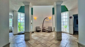 A spacious lobby with a high ceiling, large windows, and a central seating area.