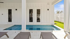 A pool area with a clear view of the pool, two doors, and a white fence in the background. - Bikes, Close Beach Access, Gulf View, Private Pool (Inlet Beach)