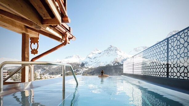 Ein Poolbereich mit Blick auf schneebedeckte Berge.