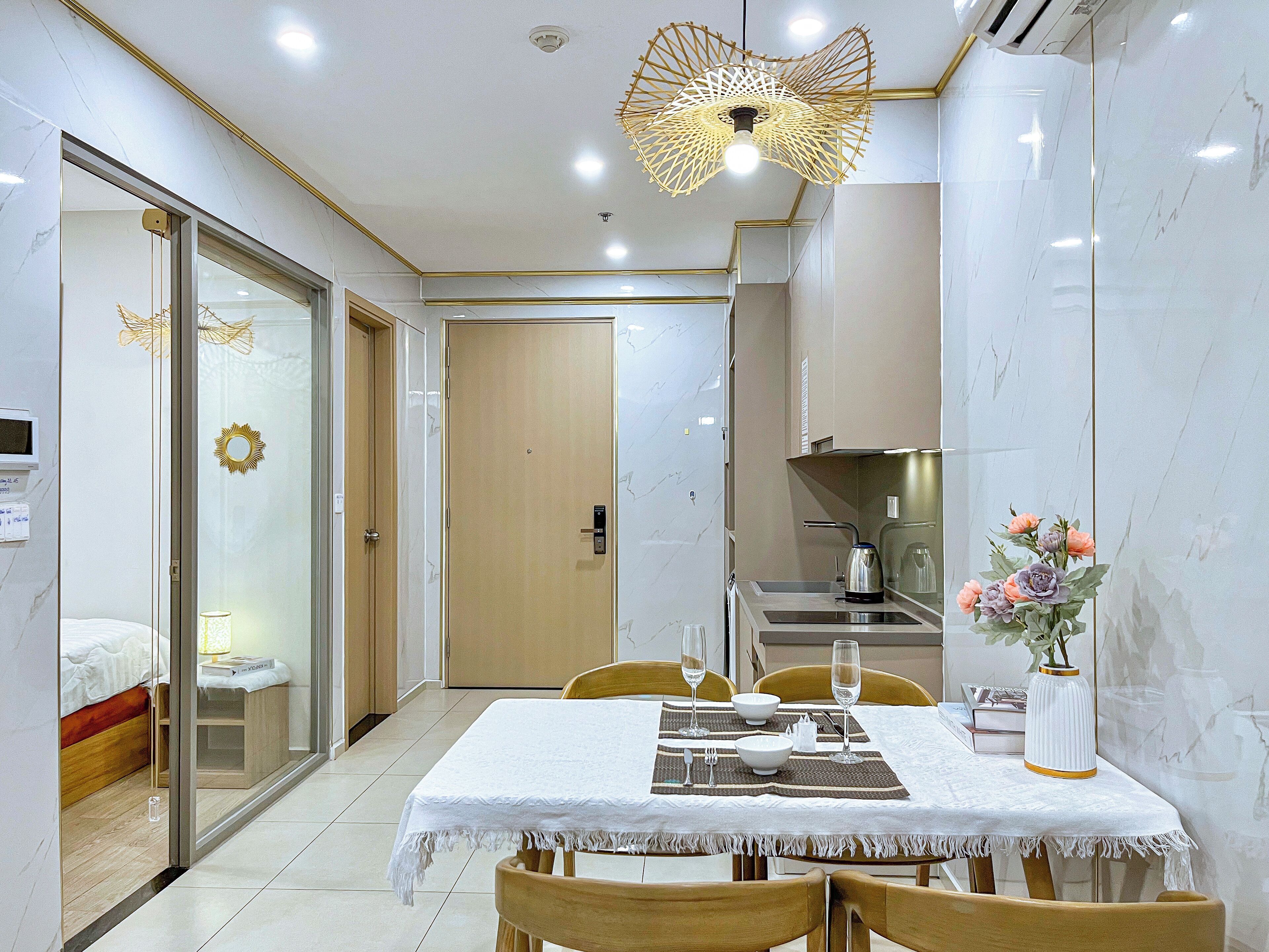 Une chambre d’hôtel moderne dotée d’un coin repas, d’une cuisine et d’une chambre à coucher séparée.