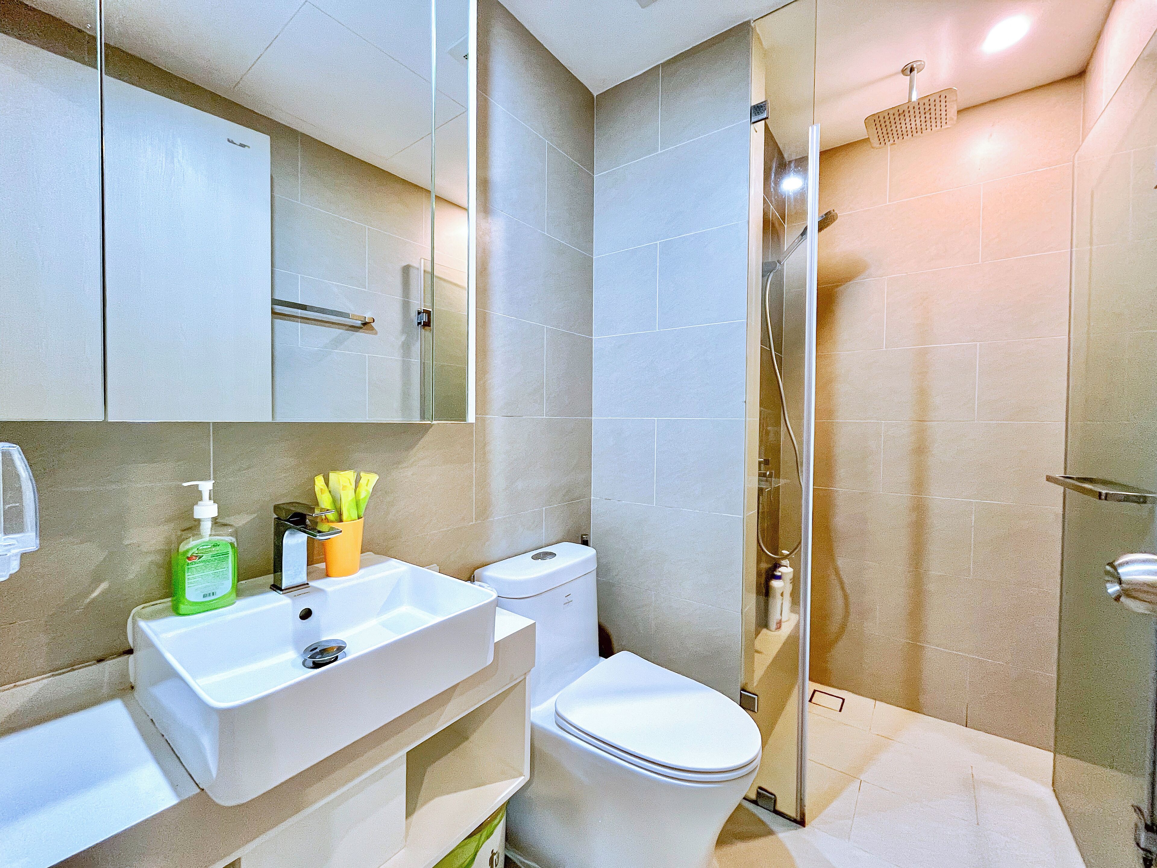 A modern bathroom with a toilet, sink, and shower.