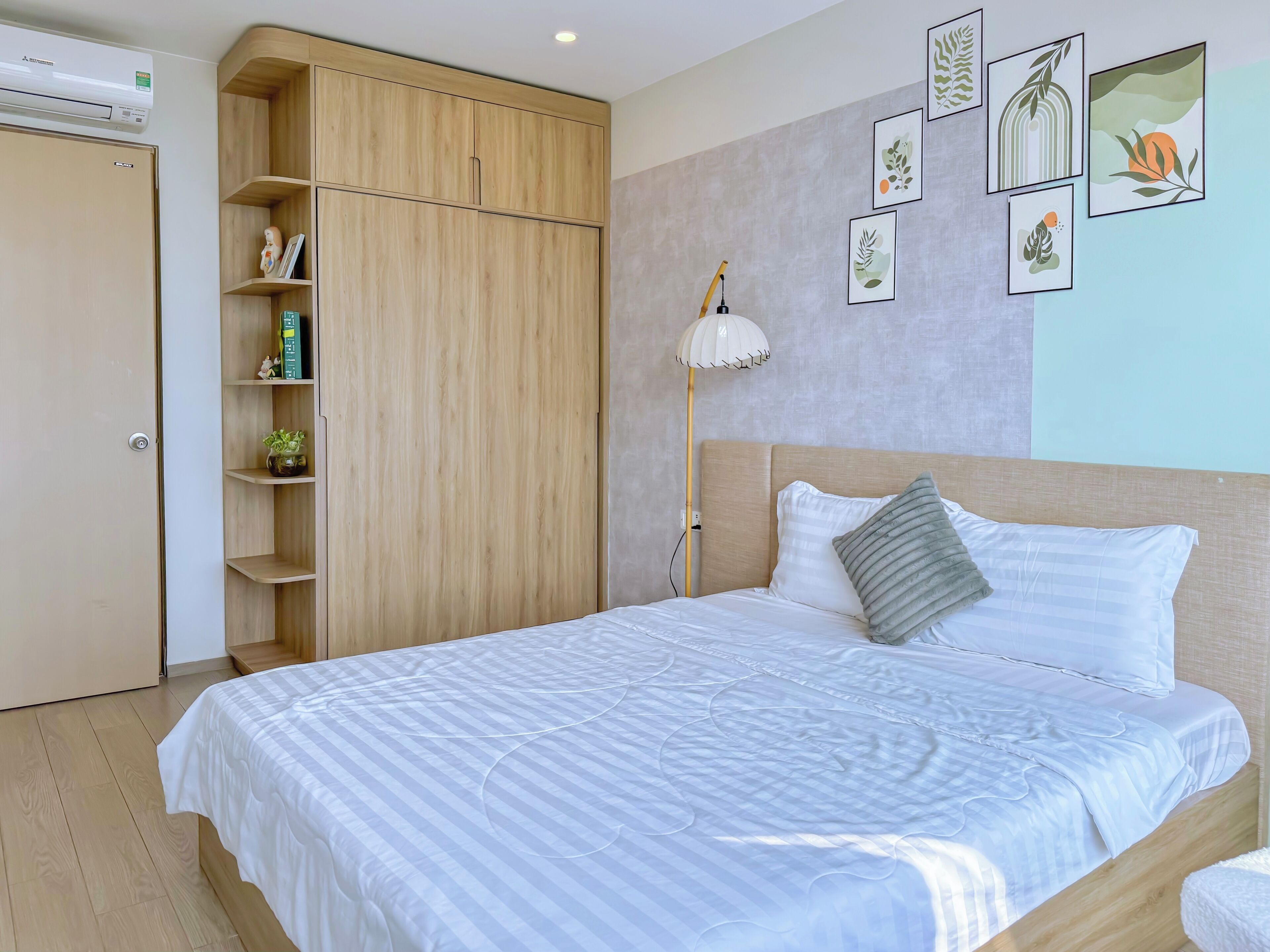 A bedroom with a bed, a wardrobe, and a bedside lamp.