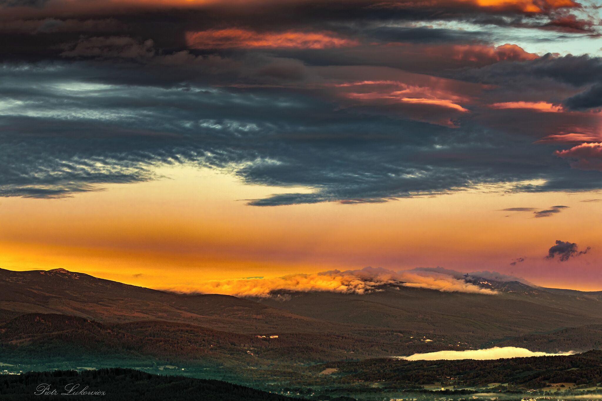 A mountainous landscape with a sunset.