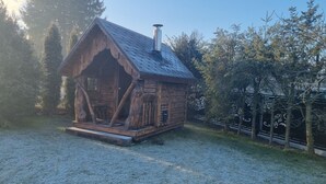 A rustic wooden cabin with a sloped roof and a chimney.