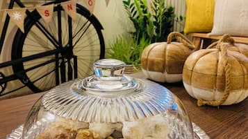 Suporte de sobremesas coberto por vidro com diversos doces sobre uma mesa de madeira.