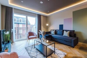 Una sala de estar moderna con un sofá, una mesa de centro y un ventanal grande.