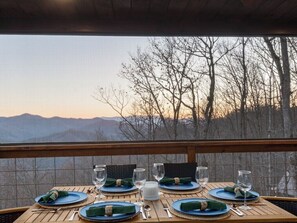 Mesa para cuatro con vista a montañas y árboles.