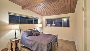A bedroom with a bed, two windows, and a wooden ceiling. - Mid-Century Steps from Miramar Beach, Private Fenced Garden in Montecito (Montecito)