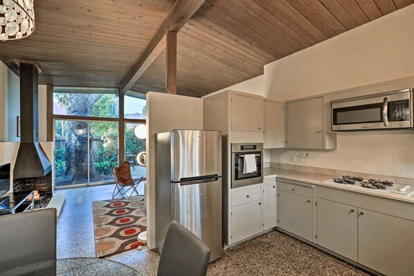 A modern kitchen with stainless steel appliances, a built-in oven, and a microwave. - Mid-Century Steps from Miramar Beach, Private Fenced Garden in Montecito (Montecito)