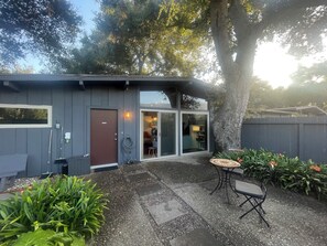 A modern house with a covered patio, a door, and a window. - Mid-Century Steps from Miramar Beach, Private Fenced Garden in Montecito (Montecito)