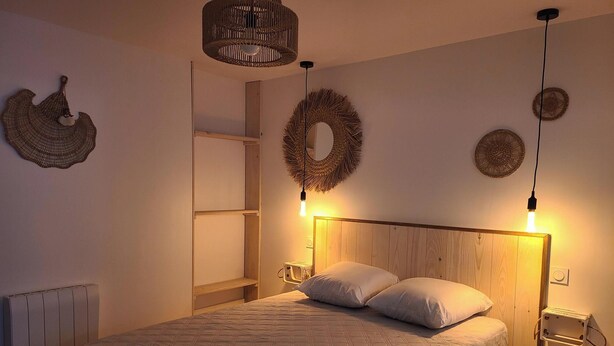 Un dormitorio con cama, mesitas de noche, un armario y adornos en la pared.