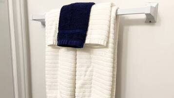 Una toalla blanca con una toalla azul sobre un toallero blanco.