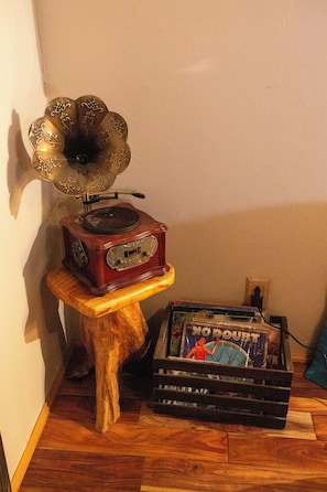 Uma mesa de madeira com um tocador de discos e uma caixa de discos de vinil.