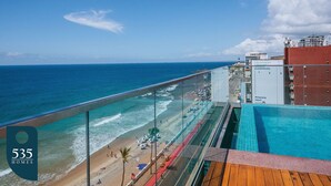 Ein Balkon mit Blick auf Strand und Meer, ein Swimmingpool und ein Schild für 535 Häuser.
