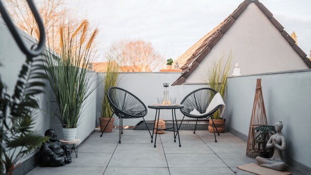 A small patio with two chairs, a table, and potted plants. - FlexHome Stylish vacation apartment (Lippstadt)