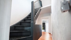 A modern staircase with dark steps and metal railings leading to a second floor. - FlexHome Stylish vacation apartment (Lippstadt)