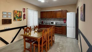 A kitchen with wooden cabinets, a microwave, and a refrigerator. - Casa La Peña (Pet friendly) 1 min drive from the beach! (La Redonela)