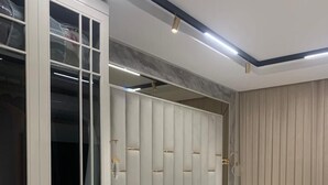 A bedroom with a bed, a wardrobe with glass doors, and a bedside table. - YİLDİRAY YİLMAZ GENEL TRADİNG FZ-LLC (Ras Al Khaimah)