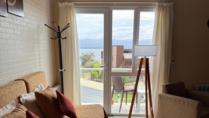 Ein Schlafzimmer mit einem Bett, einem Kleiderständer, einem Sessel und einem Tisch.