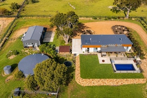 Una propiedad residencial con una casa grande, piscina y patio cercado.