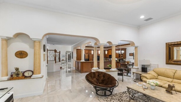 A spacious living area with a high ceiling, a kitchen in the background, and a beige sofa. - Spacious 5-bedroom house in charming Wellington with WiFi, AC (Wellington)