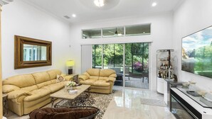 A spacious living room with two beige sofas, a coffee table, and a fireplace. - Spacious 5-bedroom house in charming Wellington with WiFi, AC (Wellington)
