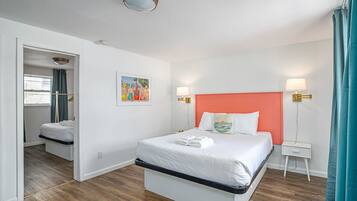 Camera d'albergo con un letto, comodini, un abat-jour e una lampada a soffitto.