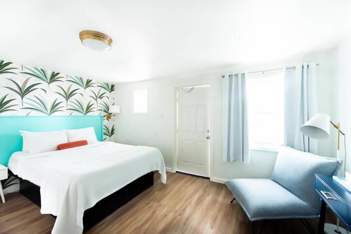 Ein modernes Hotelzimmer mit Bett, Schreibtisch und Stuhl.