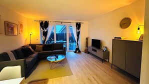 A living room with a sofa, a coffee table, a TV, and a cabinet. - Fisherman's chic "Die Bude" at the port of Maasholm (Maasholm)