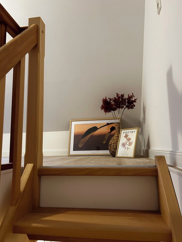 A wooden staircase with a framed picture and a vase with dried flowers on the landing. - Fisherman's chic "Die Bude" at the port of Maasholm (Maasholm)