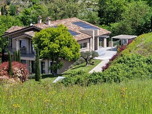 A modern house with a sloped roof, solar panels, and a well-maintained garden. - Stunning design apartment in villa, with all amenities, close to hundred. (Frosinone)