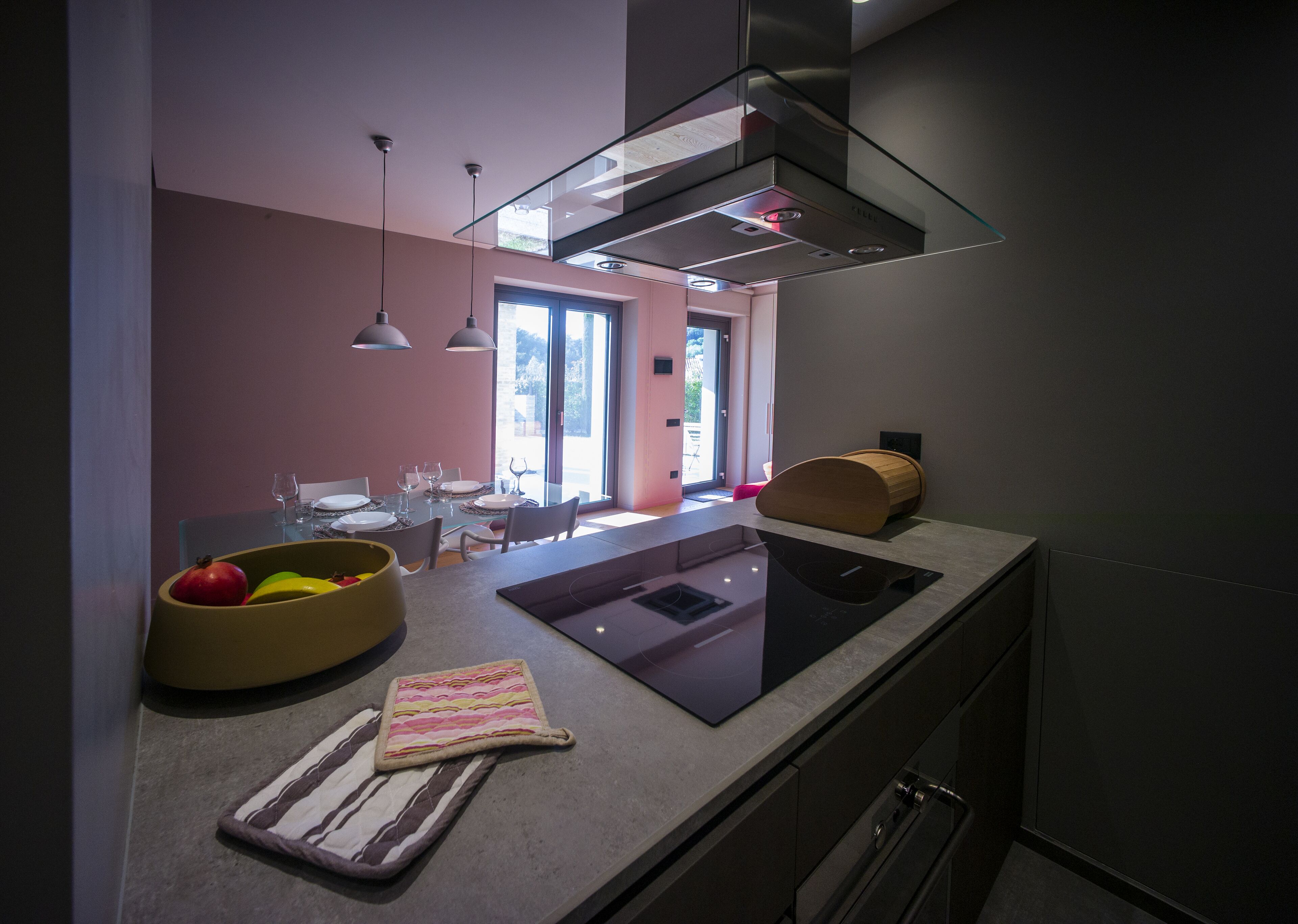 Una cocina moderna con una isla de vidrio, horno empotrado y un amplio ventanal que proporciona luz natural.
