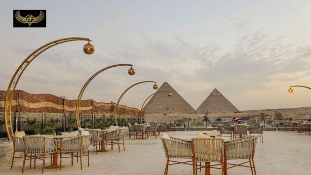 An outdoor dining area with wicker chairs and tables, overlooking the pyramids. - Comfort Inn Giza (Giza)