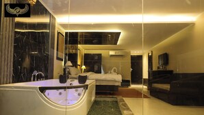 A modern hotel room with a large bathtub, a bed, a sofa, and a television. - Comfort Inn Giza (Giza)