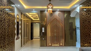 A hallway with ornate wall panels, a decorative ceiling light, and a patterned door. - Comfort Inn Giza (Giza)