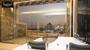 A modern bathroom with a glass shower enclosure, a white bathtub, and a glass-enclosed seating area with chairs. - Comfort Inn Giza (Giza)