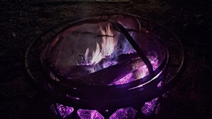 Uma cabana de madeira com porta de metal e uma pequena janela.