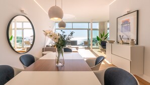 A modern dining area with a wooden table, round chairs, and a vase of flowers.