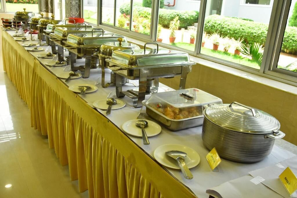 Un'impostazione per buffet con diverse postazioni di servizio, tra cui un'ampia pentola e vari piatti.